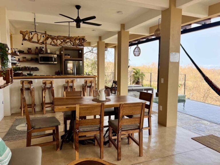 Comedor con candelabro de madera de deriva y vista a la selva
