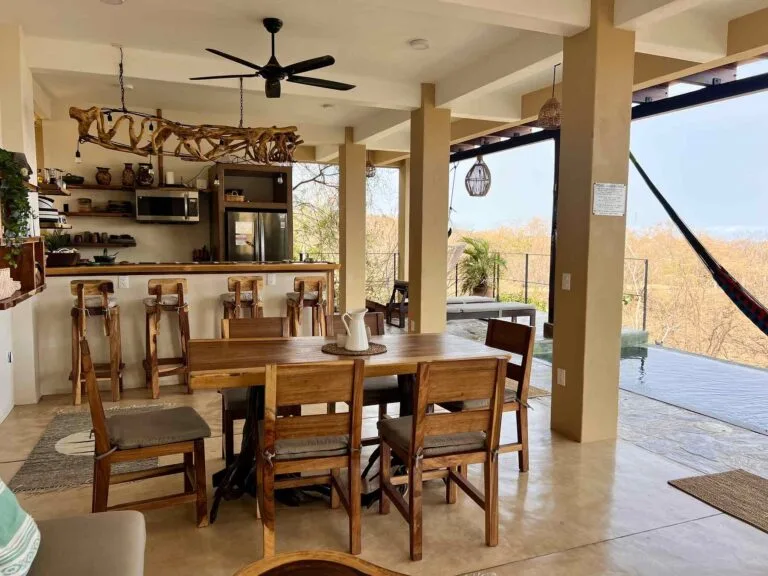 Comedor con candelabro de madera de deriva y vista a la selva