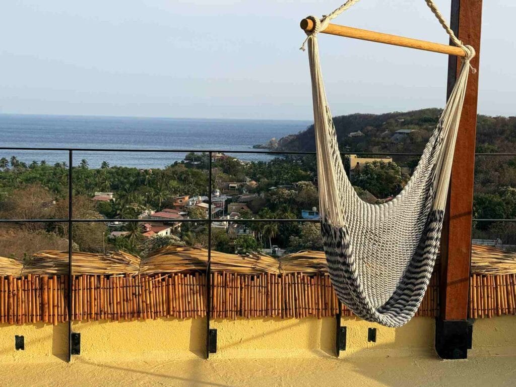 Silla hamaca de macramé en la azotea con vista a la bahía de Mazunte
