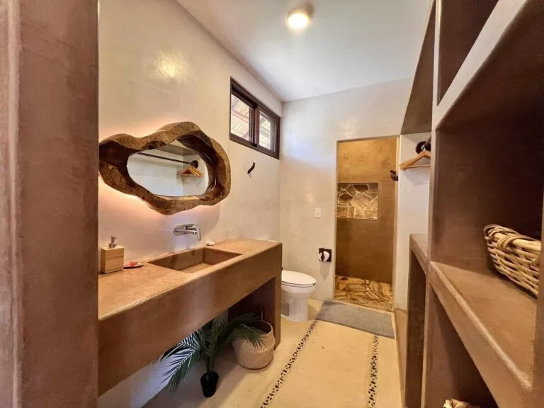 Baño privado de la Suite 2 con repisas de madera y toallas de cortesía