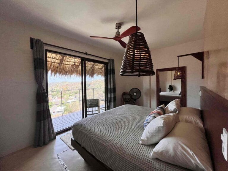 Interior de la Suite 2 con acceso al balcón y vista al mar