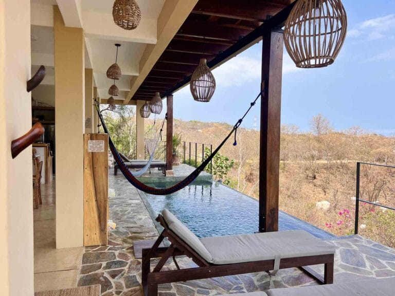 Terraza con camastros junto a la alberca infinita de Casa La Vista