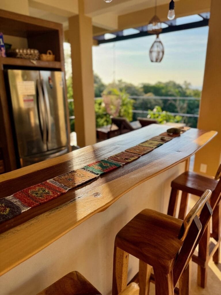 Breakfast bar with wooden stools and a stainless steel fridge in the kitchen at Casa La Vista
