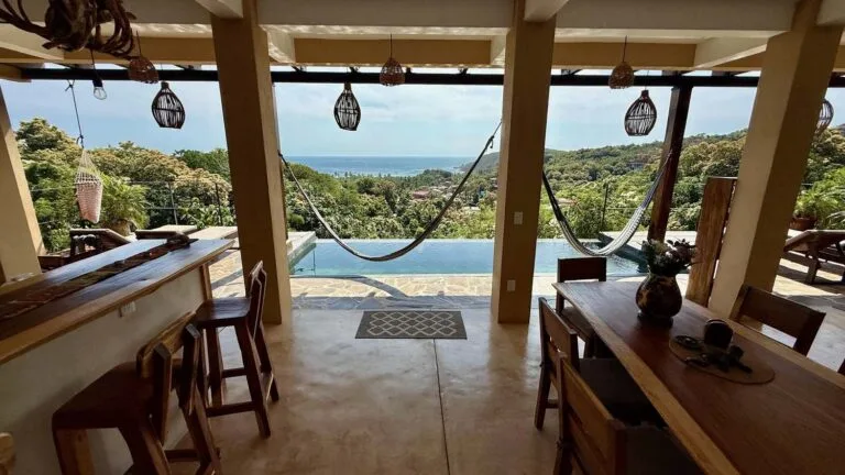 Comedor con barra de madera, alberca y hamaca con vista al mar en Casa La Vista, Mazunte