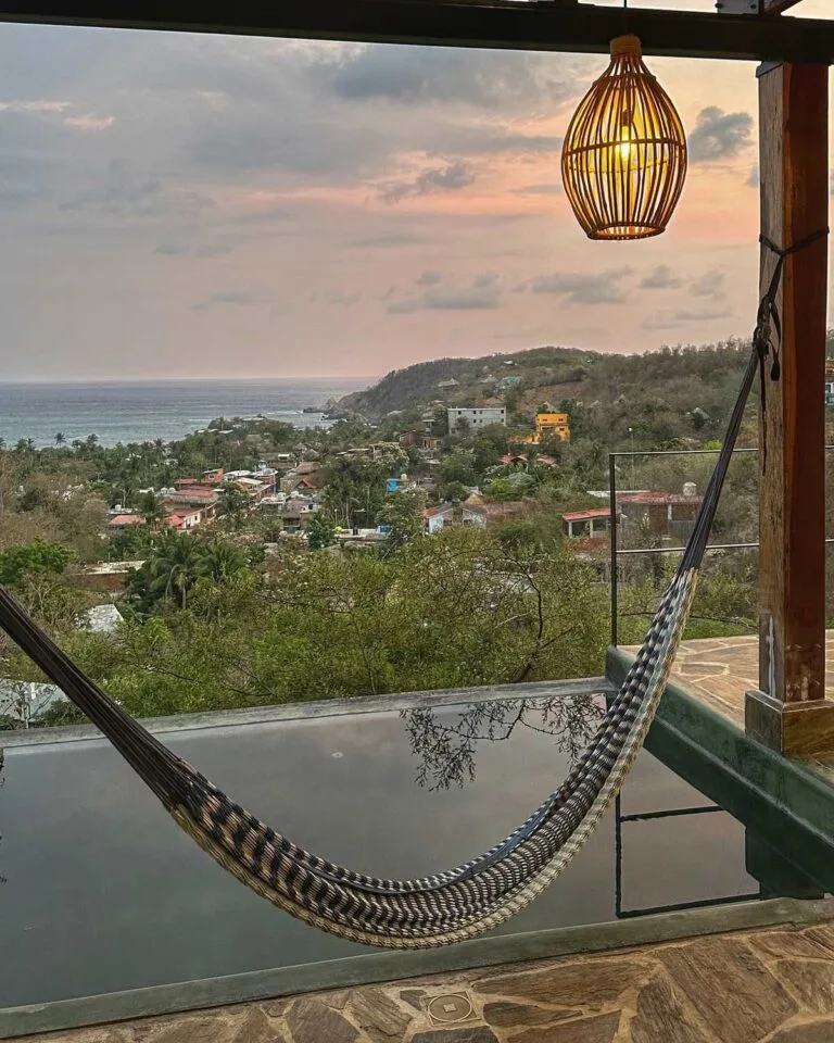 Hamaca junto a la alberca con vista a la bahía de Mazunte y nubes al atardecer