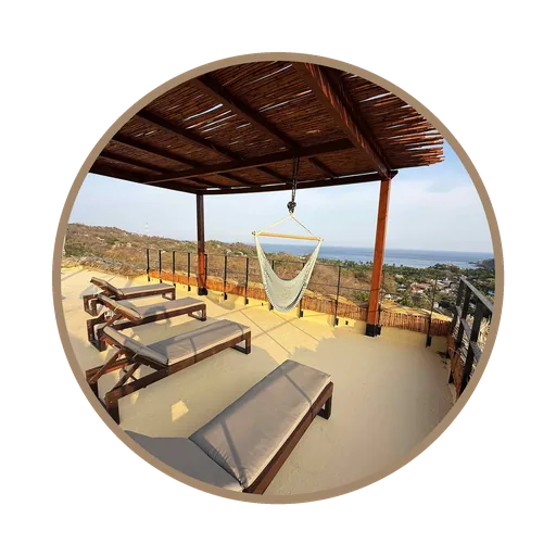 Terraza en la azotea con pérgola de madera, camastros y hamaca con vista al mar