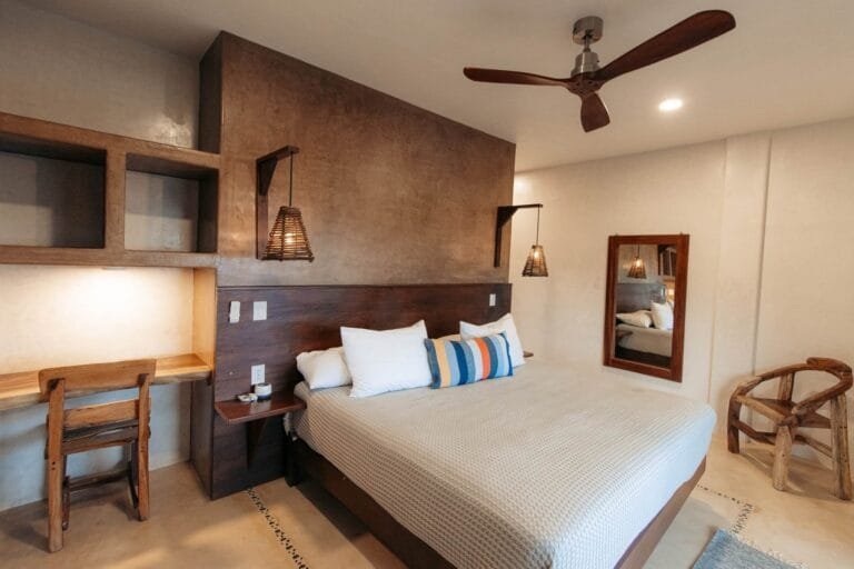 Suite 1 de Casa La Vista en Mazunte con cama king, cabecera de madera, escritorio, espejo y ventilador de techo