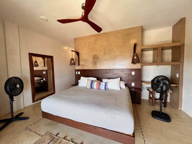 Suite 2 con cama king size, cabecera de madera y espejo en Casa La Vista, Mazunte