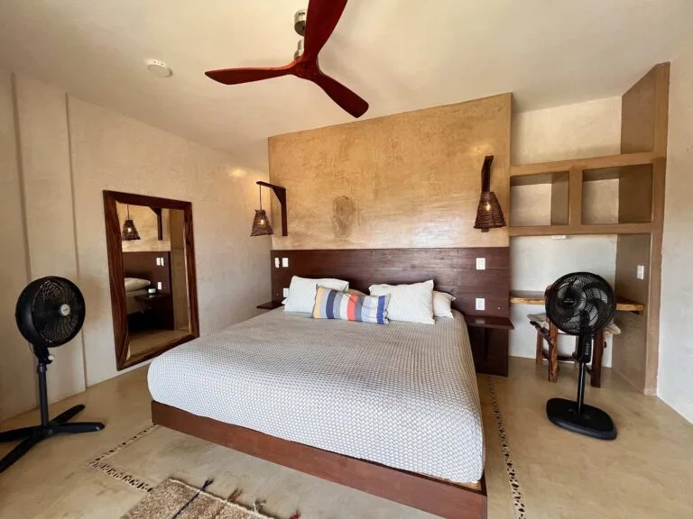 Suite 2 con cama king size, cabecera de madera y espejo en Casa La Vista, Mazunte