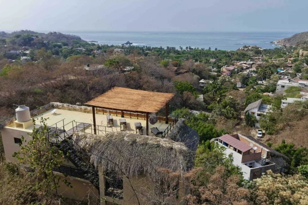 Vista aérea de Casa La Vista con la azotea con pérgola y la bahía de Mazunte al fondo