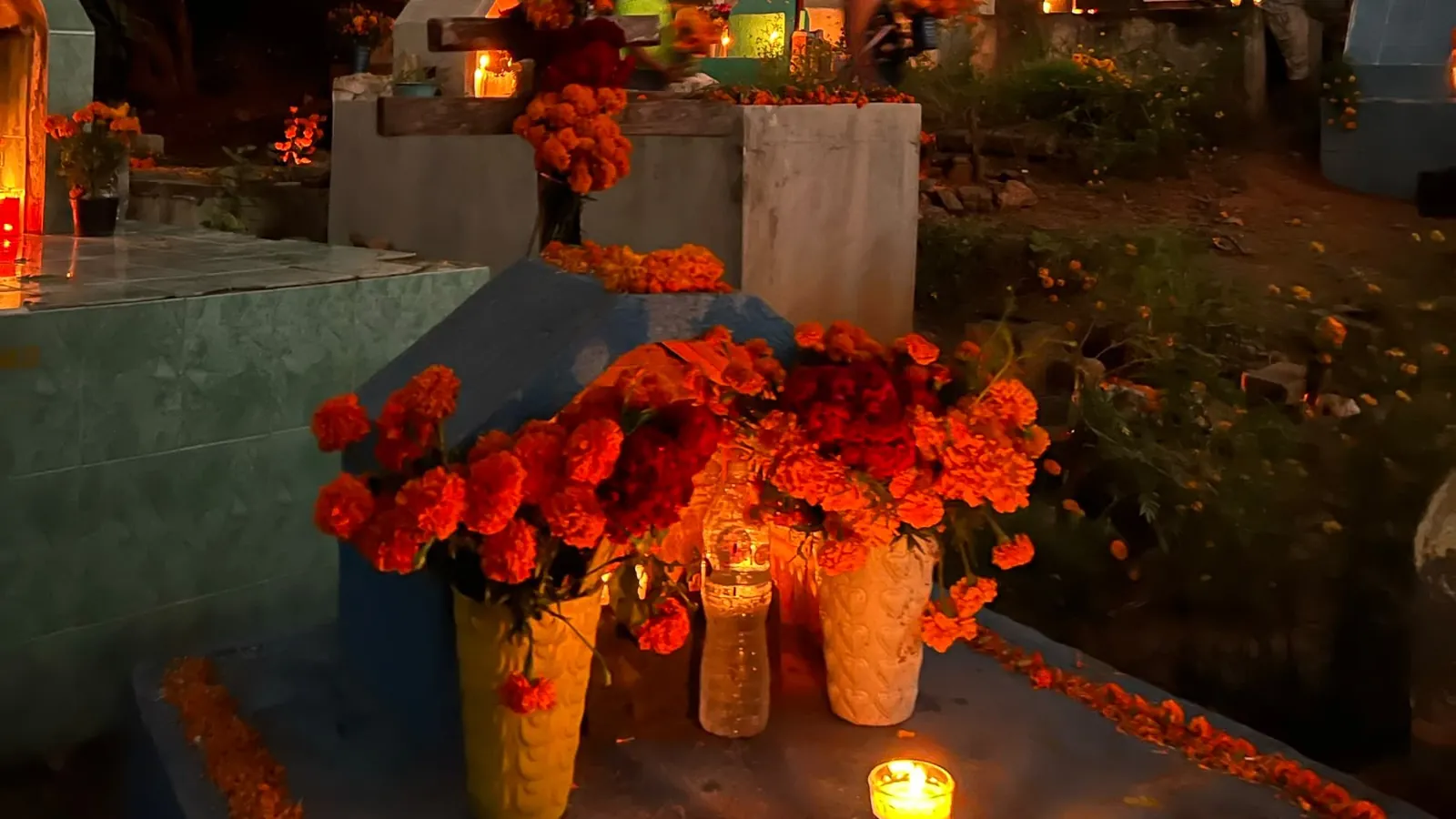 Tumbas con velas encendidas al atardecer durante el Día de Muertos en el panteón de Mazunte, Oaxaca