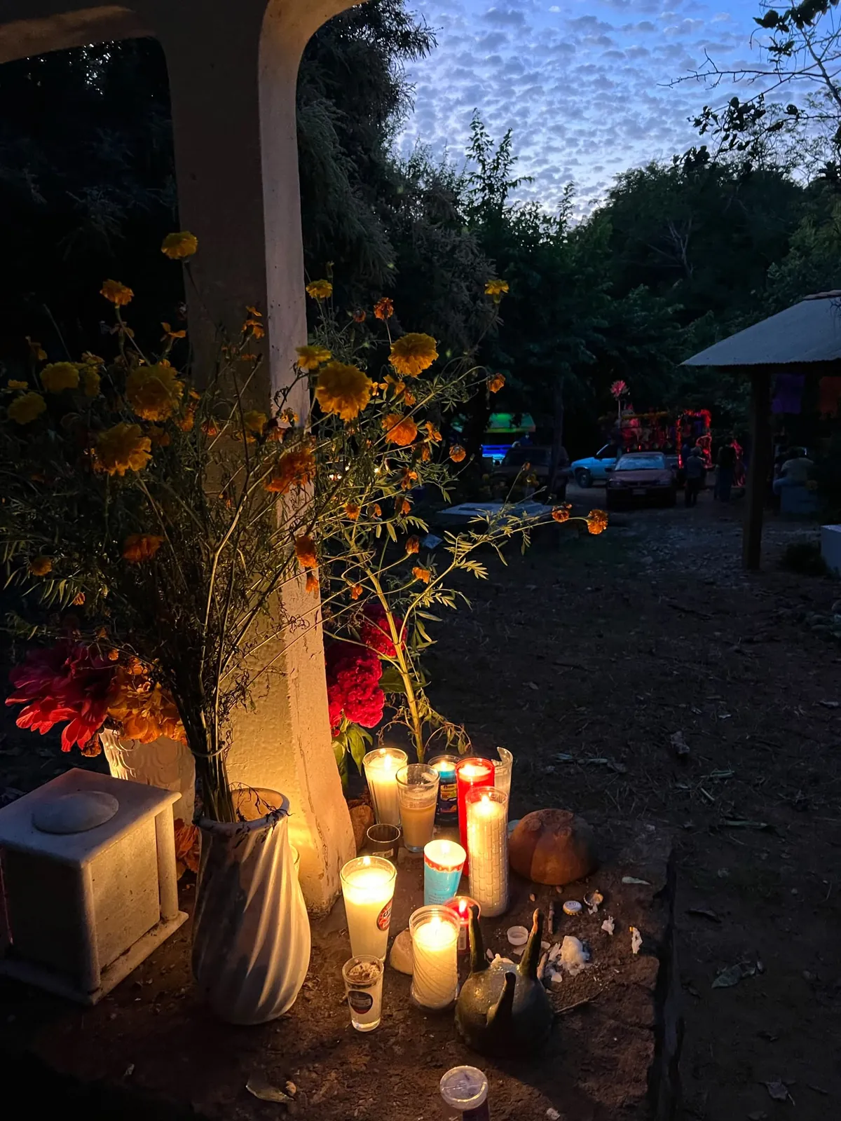 Ofrenda con velas y pan de muerto en una tumba del panteón de Mazunte