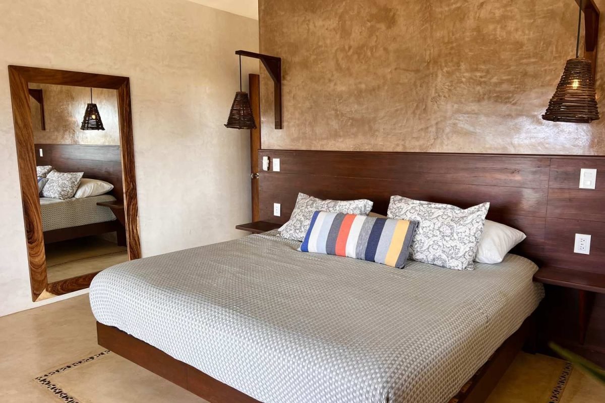 Suite 3 con cama king size, tapete artesanal y espejo en Casa La Vista, Mazunte